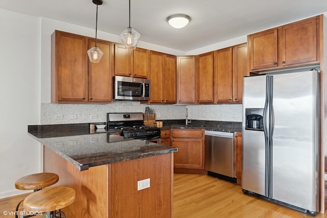 1618 S Halsted St Unit 4D, Chicago, IL 60608 - kitchen featuring stainless steel appliances, a sink, light wood finished floors, brown cabinets, and a peninsula