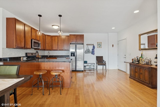 1618 S Halsted St Unit 4D, Chicago, IL 60608 - kitchen featuring appliances with stainless steel finishes, a peninsula, light wood-style flooring, decorative light fixtures, and recessed lighting