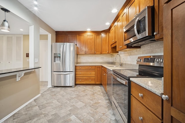 2443 E Brandenberry Ct Unit 1B, Arlington Heights, IL 60004 - kitchen with stainless steel appliances, a sink, baseboards, backsplash, and brown cabinets