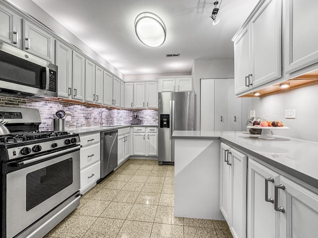 2736 N Hampden Ct Unit 105, Chicago, IL 60614 - kitchen featuring appliances with stainless steel finishes, decorative backsplash, light countertops, granite floors, and a sink