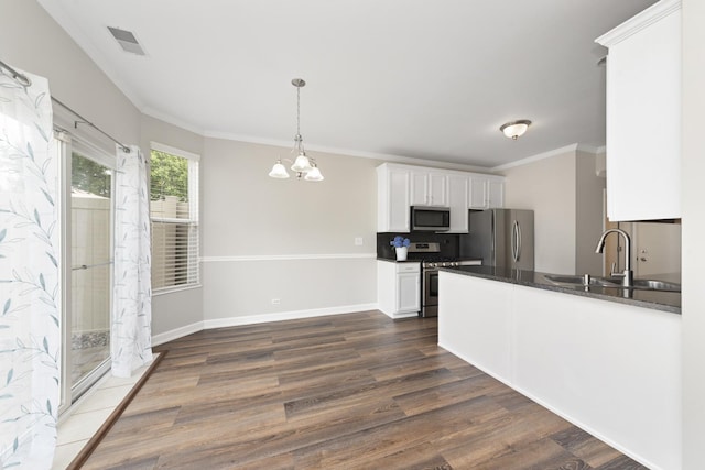 2911 Boone Ct, Joliet, IL 60435 - kitchen featuring appliances with stainless steel finishes, a sink, dark countertops, dark wood finished floors, and white cabinets