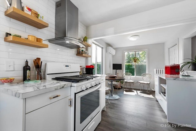 111 W N St, Plano, IL 60545 - kitchen featuring open shelves, white range with gas cooktop, island range hood, an AC wall unit, and dark wood finished floors