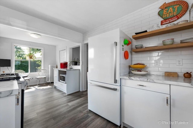 111 W N St, Plano, IL 60545 - kitchen with white appliances, radiator, light countertops, dark wood-style floors, and backsplash