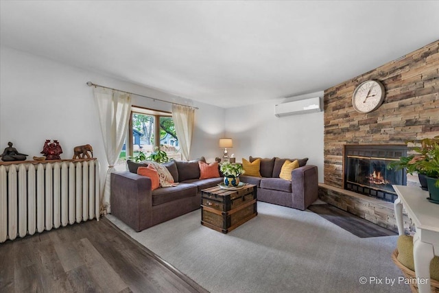 111 W N St, Plano, IL 60545 - living room featuring radiator heating unit, a wall mounted air conditioner, wood finished floors, and a stone fireplace
