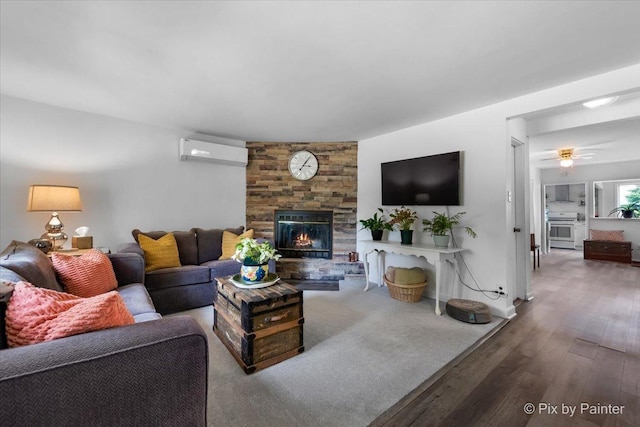 111 W N St, Plano, IL 60545 - living area featuring an AC wall unit, wood finished floors, a fireplace, ceiling fan, and baseboards
