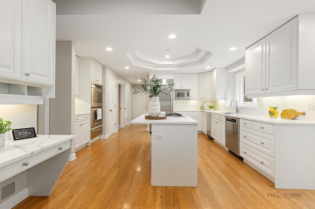 5272 Pineham Ct, Long Grove, IL 60047 - kitchen with appliances with stainless steel finishes, a sink, a raised ceiling, white cabinets, and a center island