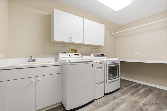5272 Pineham Ct, Long Grove, IL 60047 - laundry area featuring separate washer and dryer, cabinet space, light wood-style flooring, and baseboards