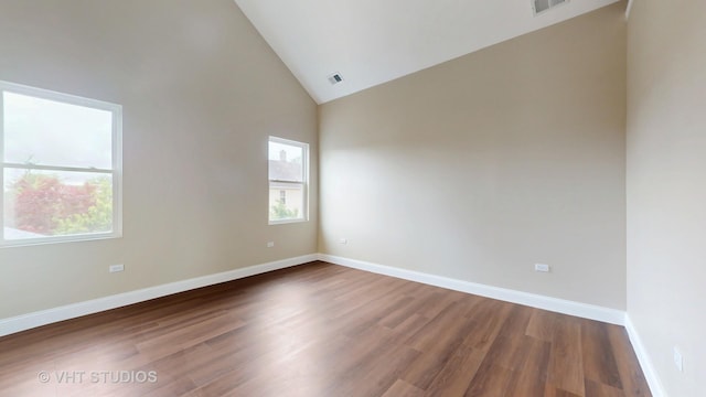 554 E Jackson St, Joliet, IL 60432 - empty room featuring wood finished floors, baseboards, and high vaulted ceiling