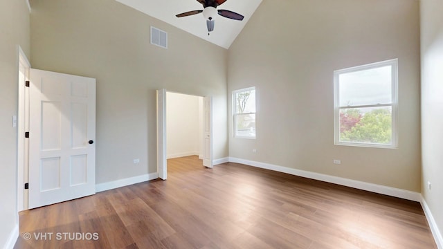 554 E Jackson St, Joliet, IL 60432 - unfurnished bedroom featuring high vaulted ceiling, multiple windows, wood finished floors, and baseboards