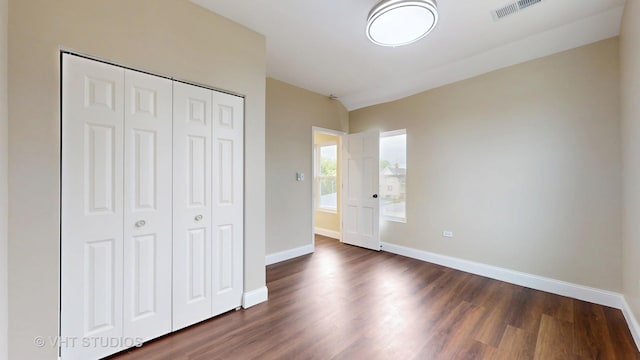 554 E Jackson St, Joliet, IL 60432 - unfurnished bedroom with baseboards, dark wood-type flooring, and a closet