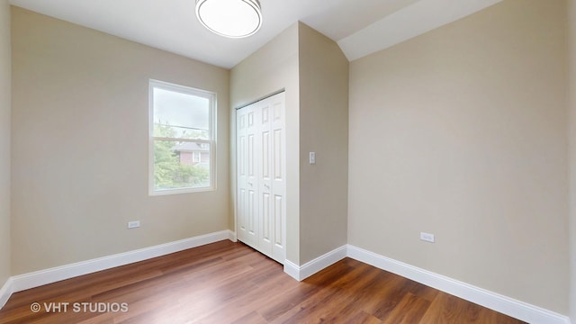 554 E Jackson St, Joliet, IL 60432 - unfurnished bedroom featuring dark wood-type flooring, baseboards, and a closet