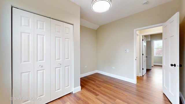 554 E Jackson St, Joliet, IL 60432 - unfurnished bedroom with light wood-style flooring, baseboards, and a closet