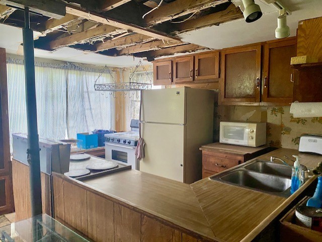 27844 1260 N Ave, Princeton, IL 61356 - kitchen featuring white appliances, brown cabinetry, and a sink