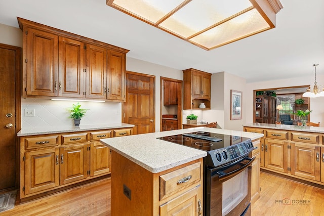 2872 Whispering Oaks Ct, Buffalo Grove, IL 60089 - kitchen featuring electric range, a kitchen island, light wood-style flooring, backsplash, and light stone countertops