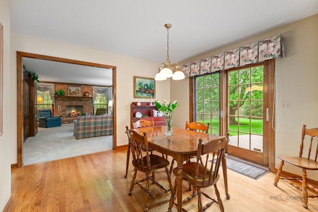 2872 Whispering Oaks Ct, Buffalo Grove, IL 60089 - dining area with light wood-type flooring, a brick fireplace, and baseboards