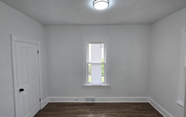 unfurnished room featuring plenty of natural light, baseboards, and dark wood-style flooring
