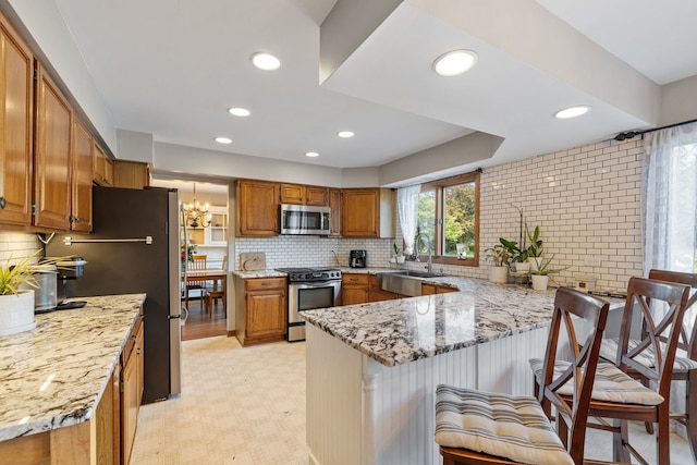 8340 W Monee Manhattan Rd, Monee, IL 60449 - kitchen with stainless steel appliances, a peninsula, brown cabinets, light stone counters, and light floors