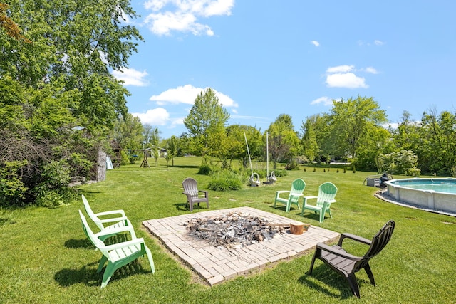 8340 W Monee Manhattan Rd, Monee, IL 60449 - view of green lawn with an outdoor pool, a fire pit, and view of wooded area