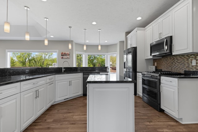 13084 Deer Xing, Roscoe, IL 61073 - kitchen with appliances with stainless steel finishes, a sink, white cabinetry, a kitchen island, and backsplash