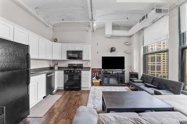 633 S Plymouth Ct Unit 701, Chicago, IL 60605 - kitchen with black appliances, open floor plan, dark wood-type flooring, white cabinetry, and a high ceiling