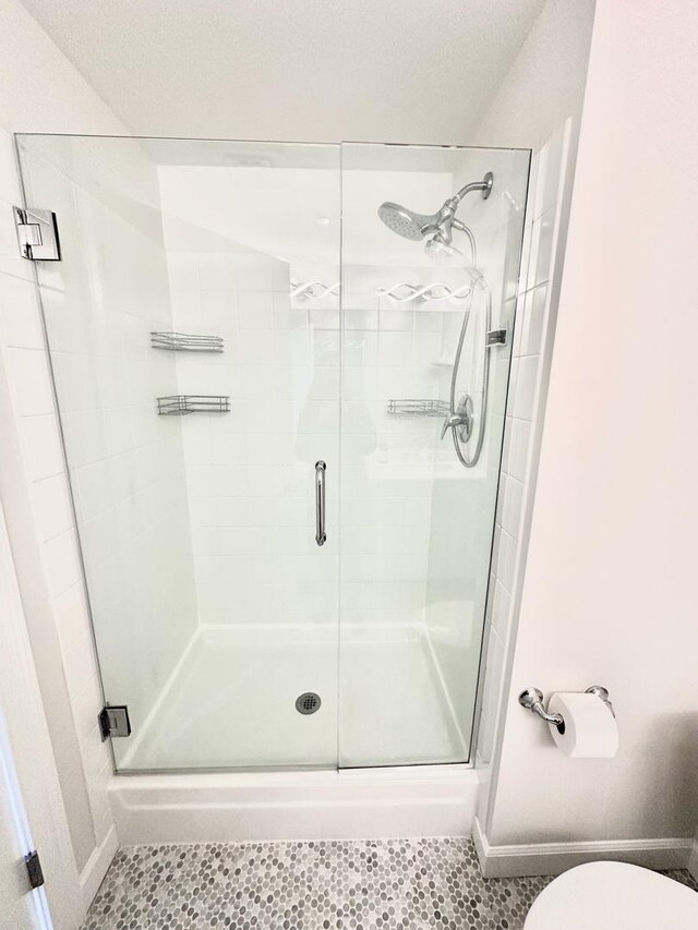 208 W Washington St Unit 1711, Chicago, IL 60606 - bathroom with a stall shower, toilet, tile patterned flooring, and baseboards