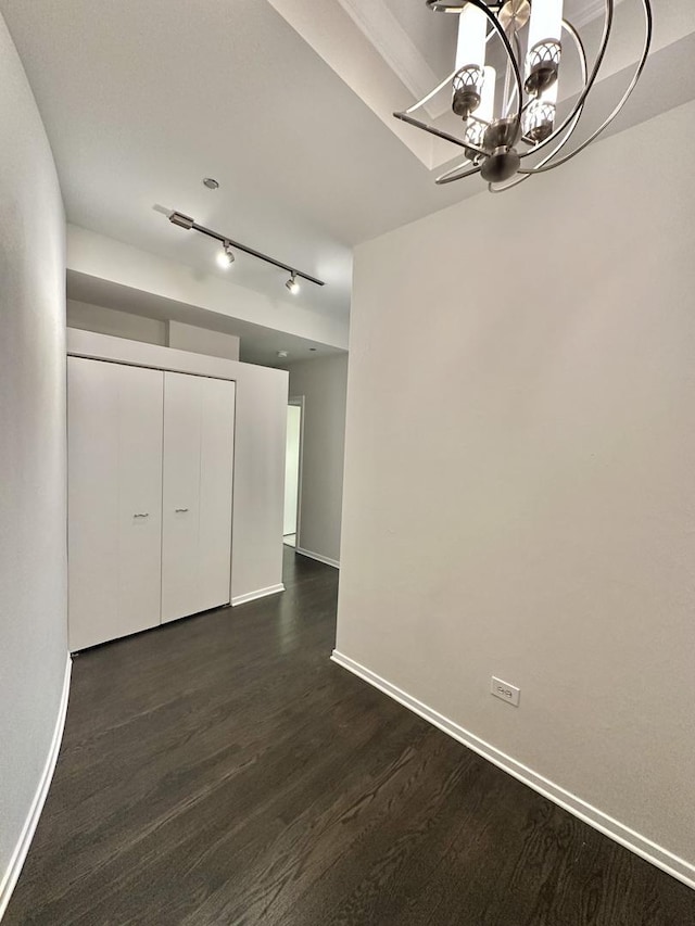 208 W Washington St Unit 1711, Chicago, IL 60606 - unfurnished dining area with a chandelier, baseboards, dark wood-style floors, and rail lighting