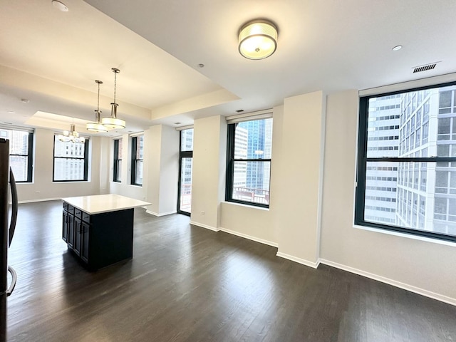 208 W Washington St Unit 1711, Chicago, IL 60606 - kitchen featuring dark cabinetry, open floor plan, a tray ceiling, and dark wood-type flooring