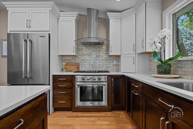 705 Meadows Rd, Geneva, IL 60134 - kitchen with stainless steel appliances, wall chimney exhaust hood, light countertops, and white cabinets