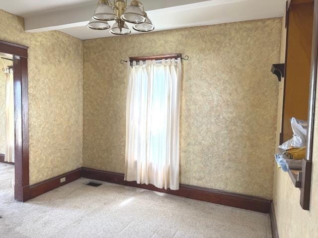 903 S Division Ave, Polo, IL 61064 - carpeted empty room with a chandelier, beamed ceiling, and baseboards