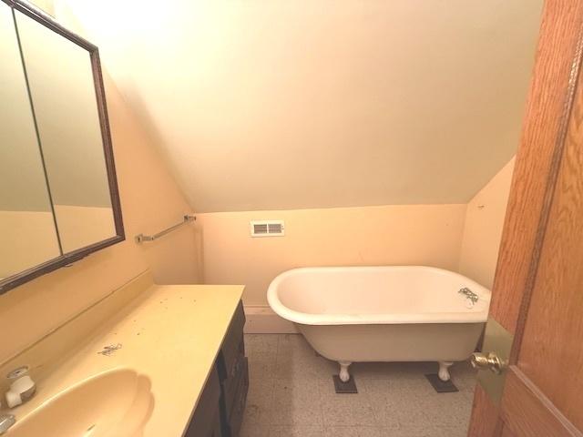 903 S Division Ave, Polo, IL 61064 - bathroom with a soaking tub, vanity, tile patterned floors, and vaulted ceiling