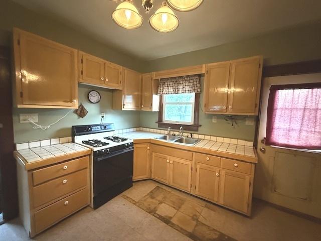 903 S Division Ave, Polo, IL 61064 - kitchen featuring gas range gas stove, a sink, and tile counters