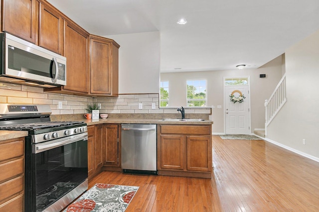 101 E Robinson Ave, Cortland, IL 60112 - kitchen featuring appliances with stainless steel finishes, a sink, light wood-style floors, brown cabinetry, and recessed lighting