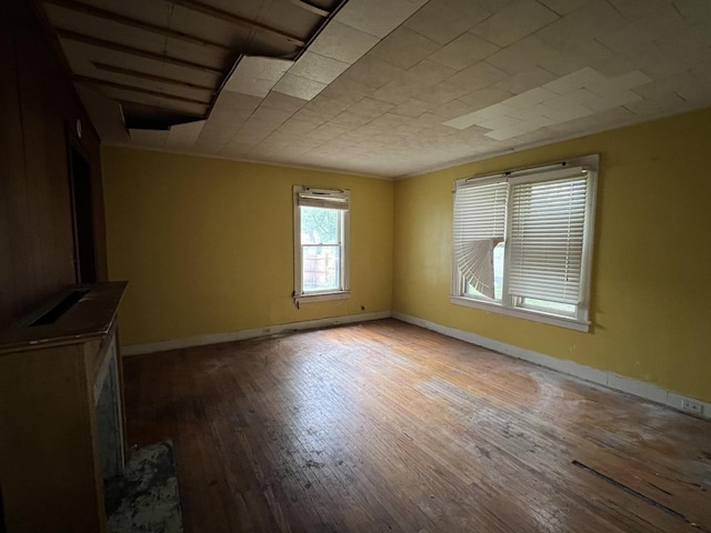 unfurnished living room with wood-type flooring and baseboards