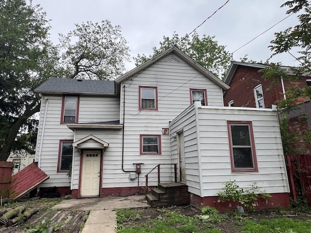 back of property featuring roof with shingles