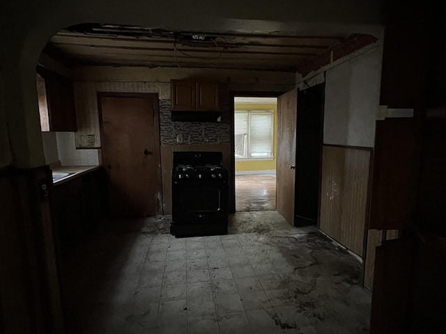 kitchen featuring gas stove, arched walkways, and light countertops