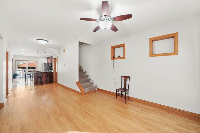 7050 26th Pkwy, Berwyn, IL 60402 - unfurnished living room with light wood-style flooring, stairs, and a ceiling fan