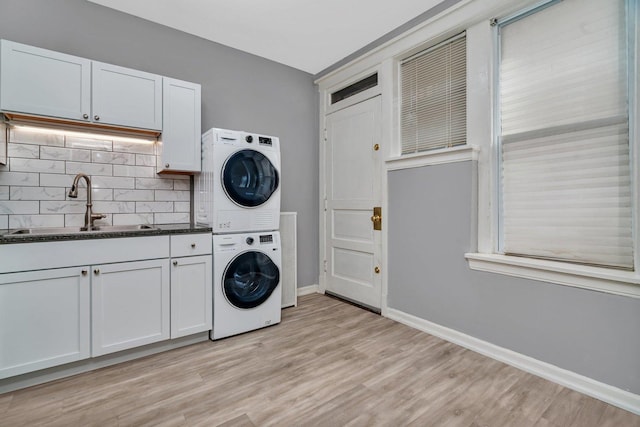 2749 N Hampden Ct Unit 1E, Chicago, IL 60614 - washroom with estacked washer and dryer, baseboards, light wood-type flooring, and cabinet space