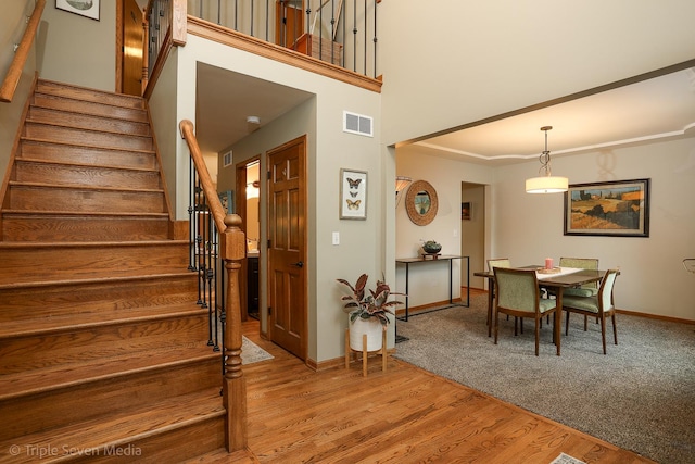 14822 S Eagle Ridge Dr, Homer Glen, IL 60491 - dining room with stairs, baseboards, light wood-style flooring, ornamental molding, and a towering ceiling