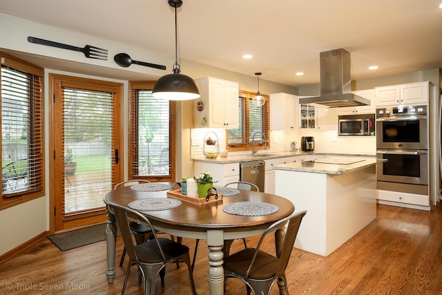 14822 S Eagle Ridge Dr, Homer Glen, IL 60491 - kitchen featuring appliances with stainless steel finishes, island range hood, a sink, a center island, and decorative backsplash