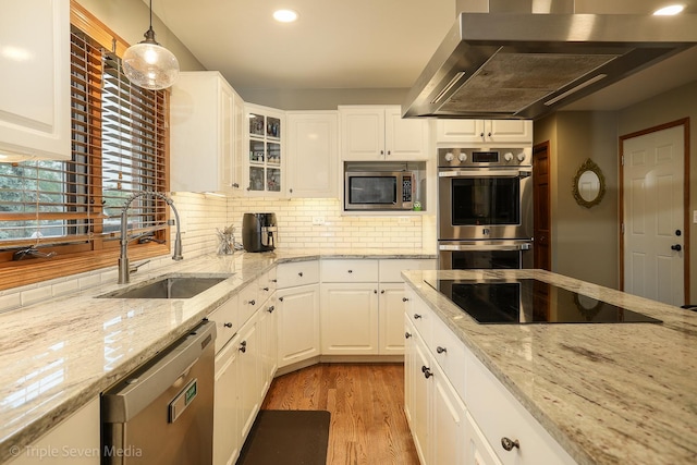 14822 S Eagle Ridge Dr, Homer Glen, IL 60491 - kitchen featuring stainless steel appliances, a sink, wall chimney range hood, tasteful backsplash, and light wood-style floors