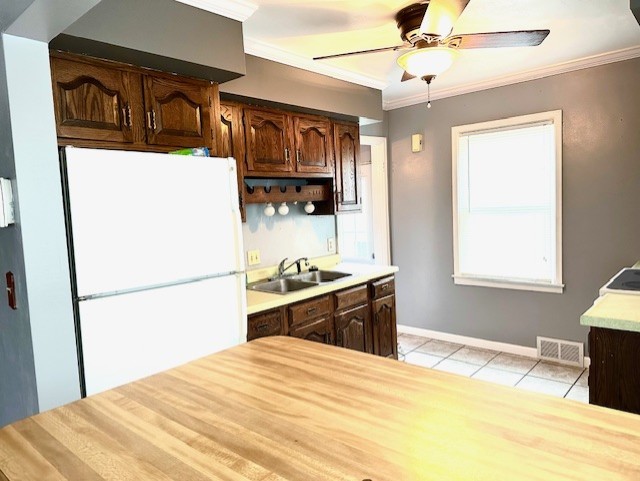 913 Academy St, Dixon, IL 61021 - kitchen with freestanding refrigerator, a sink, light countertops, ornamental molding, and light tile patterned floors