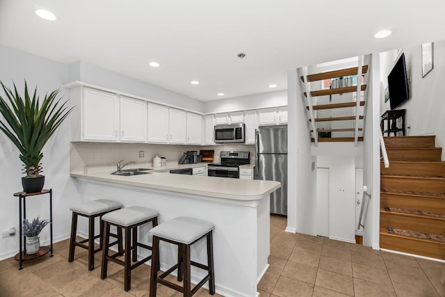 1203 Central St Unit C, Evanston, IL 60201 - kitchen featuring stainless steel appliances, a sink, light countertops, a peninsula, and a kitchen breakfast bar