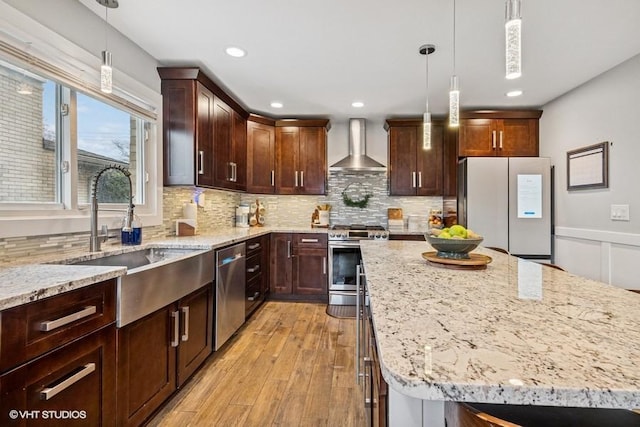 7146 S Oketo Ave, Bridgeview, IL 60455 - kitchen with wall chimney range hood, stainless steel appliances, a sink, light stone counters, and light wood-style floors