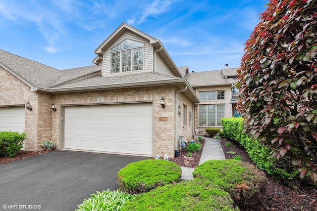 8806 175th St, Tinley Park, IL 60487 - view of front facade featuring asphalt driveway, a garage, a shingled roof, and brick siding