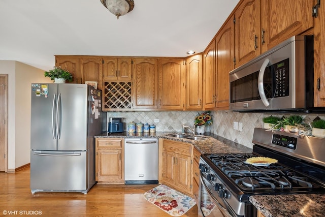 8806 175th St, Tinley Park, IL 60487 - kitchen with stainless steel appliances, a sink, light wood-style floors, brown cabinets, and tasteful backsplash