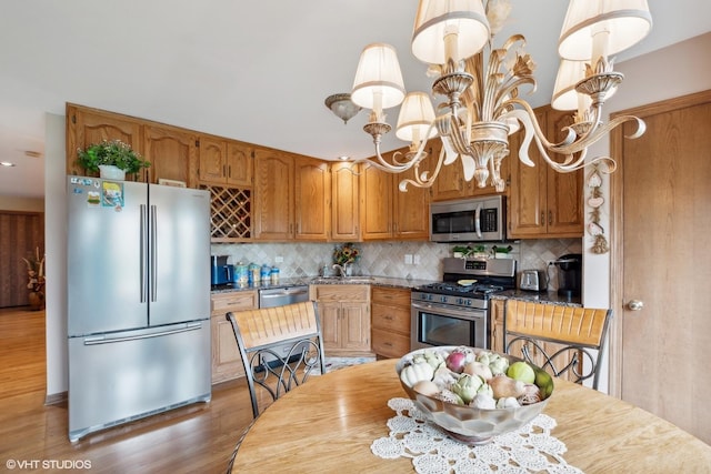 8806 175th St, Tinley Park, IL 60487 - kitchen featuring appliances with stainless steel finishes, decorative backsplash, light wood finished floors, brown cabinets, and recessed lighting