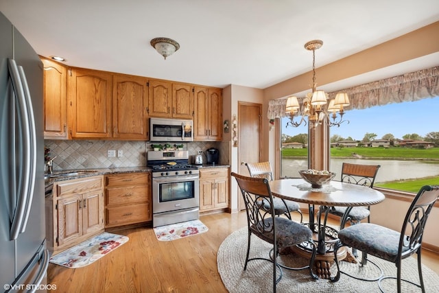 8806 175th St, Tinley Park, IL 60487 - kitchen with appliances with stainless steel finishes, a chandelier, light wood-style floors, and backsplash
