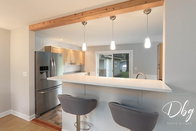 36509 N Traer Ter, Gurnee, IL 60031 - kitchen with stainless steel refrigerator with ice dispenser, light brown cabinetry, light countertops, and a kitchen breakfast bar