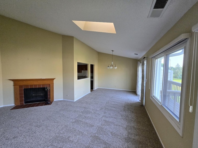 143 W Fabish Dr Unit 143, Buffalo Grove, IL 60089 - unfurnished living room featuring a chandelier, dark carpet, a fireplace, vaulted ceiling, and a skylight