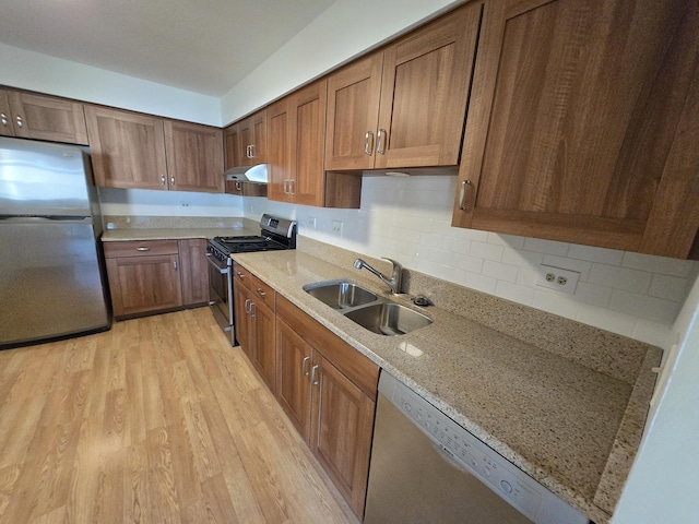 143 W Fabish Dr Unit 143, Buffalo Grove, IL 60089 - kitchen with appliances with stainless steel finishes, under cabinet range hood, light wood finished floors, light stone counters, and tasteful backsplash